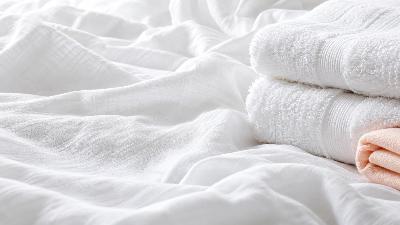 Fresh white cotton linen and soft towels with a peach cloth